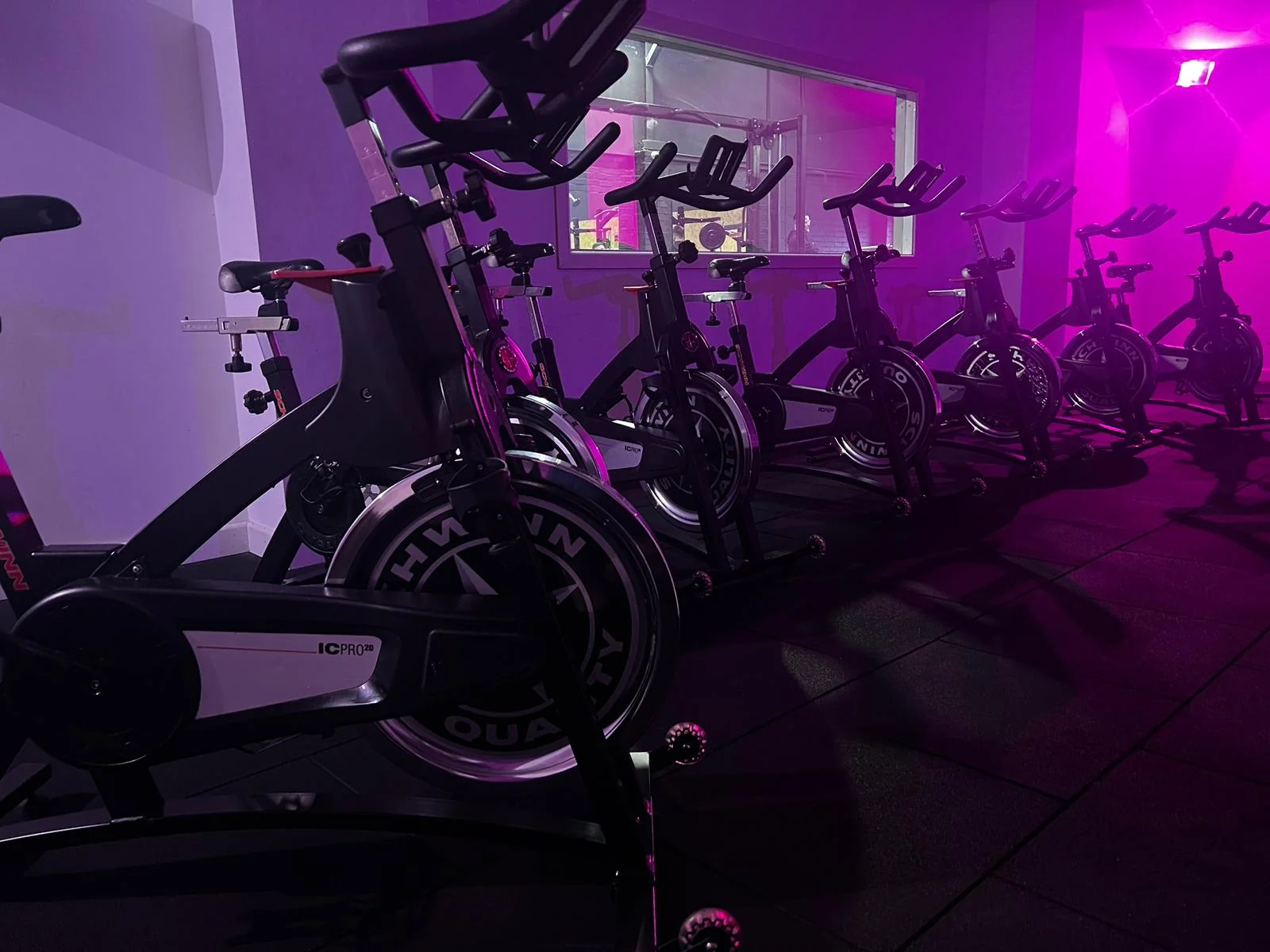 Indoor cycling studio with spin bikes during high-energy class at Unit 9 Gym Neath Wales